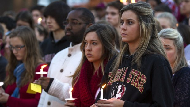 Sombre: Thousands of FSU students attended a vigil after the campus shooting.