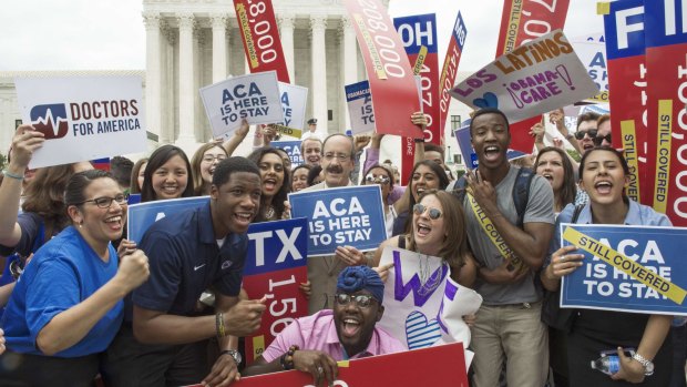 Celebrating ... Supporters rally in front of the Supreme Court in Washington DC after the court's announcement of the decision affirming the Affordable Care Act. 