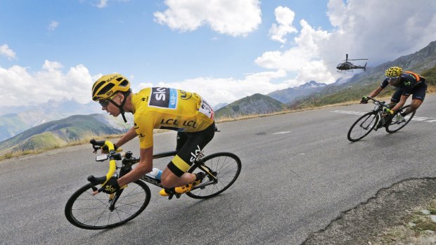 Britain's Chris Froome, wearing the overall leader's yellow jersey, and Spain's Alejandro Valverde, right, speed downhill during the 19th stage.