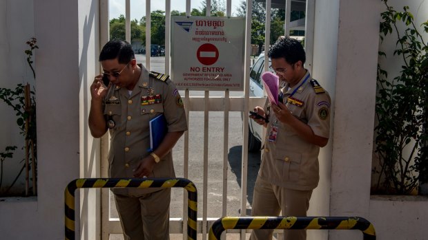 Security guards at Phnom Penh airport on Thursday. waiting for the refugees to land.