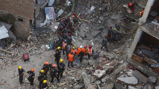 Members of a rescue team from Hungary and Nepal armed police personnel search for earthquake survivors under the debris of a collapsed building, in Kathmandu.