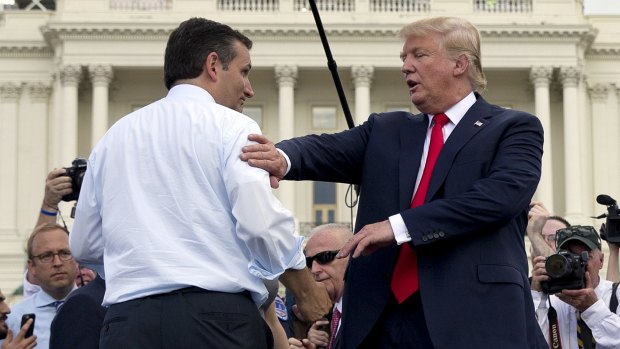 Pat on the back ... Republican presidential candidates Donald Trump and Senator Ted Cruz greet each other on stage at the Tea Party Patriots rally.