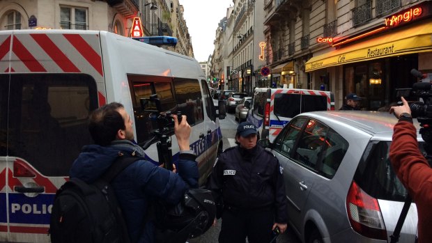 A police officer prevents access to a street as police officers search an apartment in connection with the attack at the Louvre.