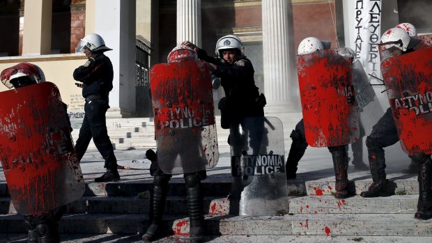 Riot police splattered with red paint thrown by protesters in Athens on Thursday.