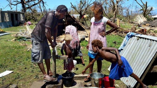 Locals pump water from the well in their coastal village on the island of Tanna.