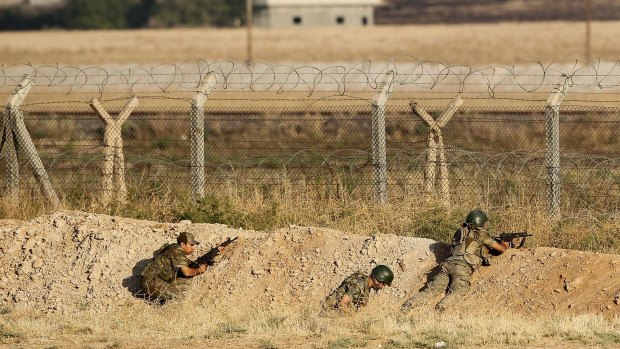 Turkish soldiers take position in June at the Syrian border fence, near the Turkish border town of Akcakale.
