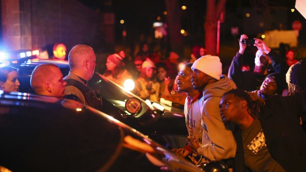 Demonstrators confront Minneapolis police officers outside the 4th Precinct station on Sunday night. 