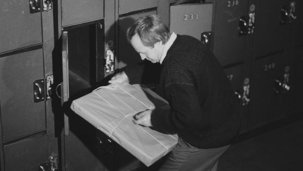 Victoria Police forensic scientist Neil Holland removes the package containing the painting from locker 227 Spencer Street Station on August 20, 1986.