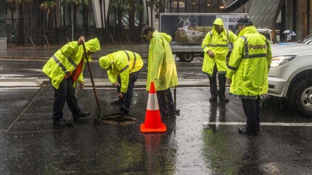 Road crews work in the rain in the Brisbane central business district.