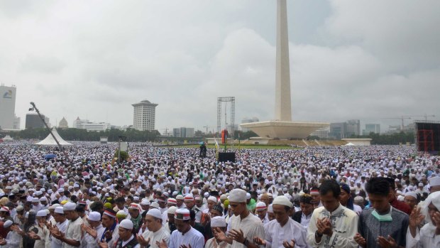 Tens of thousands take part in a prayer at Jakarta's National Monument during the December 2 rally against Jakarta's governor Ahok.