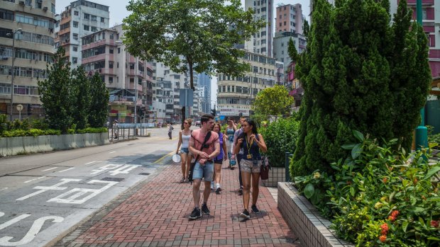 Alla Lau, right, a travel guide, right, from Hong Kong Free Tours, leads tourists through the Sham Shui Po section of Hong Kong.