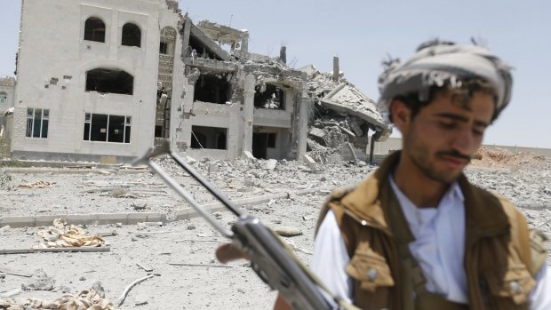 A militant outside the residence of the Houthi commander, Abdullah Yahya al Hakim, after an air strike destroyed it on Tuesday.