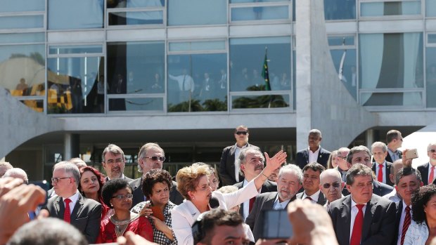 Suspended Brazilian President Dilma Rousseff (centre) speaks to supporters outside the Planalto presidential palace after the Senate voted to accept impeachment charges against her. 