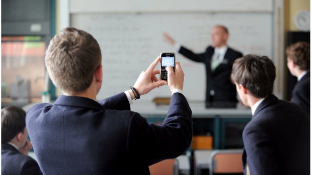 Students at a school in Melbourne use their mobile phones in class.