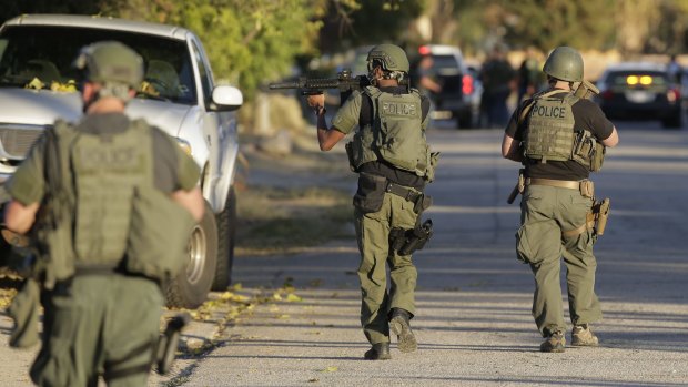 Police officers search for a suspect in a mass shooting in San Bernardino, California on Wednesday.