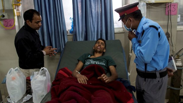Rishi Khanal speaks to a security guard at a hospital in Kathmandu.