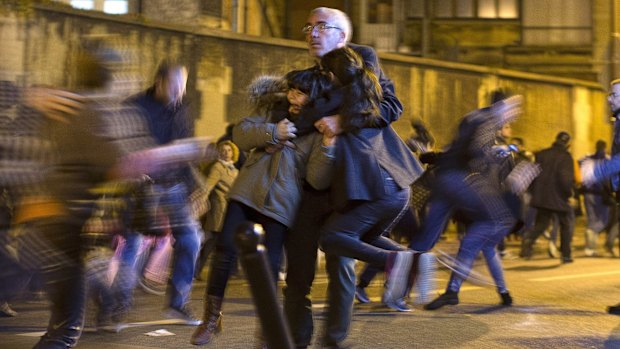 A man carries two children after panic broke out.