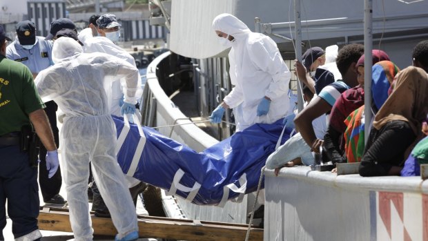 Continuing crisis ... Forensic police officers disembark the body of a migrant from the Croatian vessel SB 72 Mohorovicic, at Reggio Calabria Harbour, Italy on Monday.