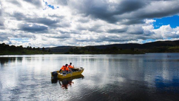 Workers on Googong Dam test the water quality in April. 