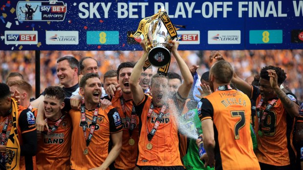 Back in the big time: Hull City's Michael Dawson lifts the trophy after winning the Championship play-off final against Sheffield Wednesday at Wembley Stadium.