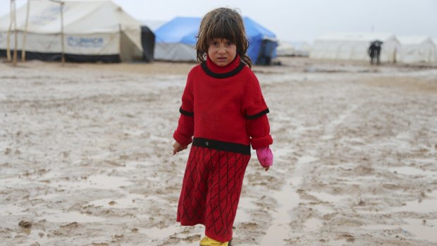 Treated like chattel by Islamic State ... A refugee girl from the minority Yazidi sect stands on a muddy path outside tents during wintry weather at Nowruz refugee camp in Qamishli, northeastern Syria. 