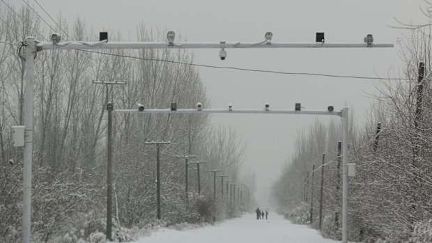 Surveillance cameras keep watch on a road in Akto County, Xinjiang.