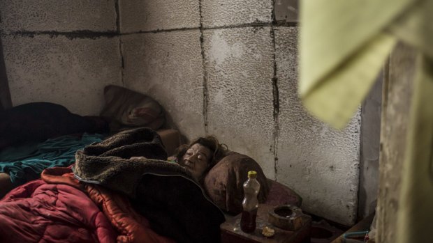 Unable to walk, Lyuba Sklyarova lies beneath layers of  blankets in a tottering house in Debaltseve.