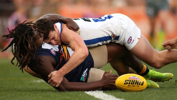 No quarter given: Nic Naitanui of the Eagles and Scott Thompson of the Kangaroos wrestle near the boundary line.