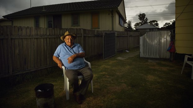 Indigenous elder Uncle Wes Marne sits by his fire bucket in his backyard in Blackett, Sydney. 
