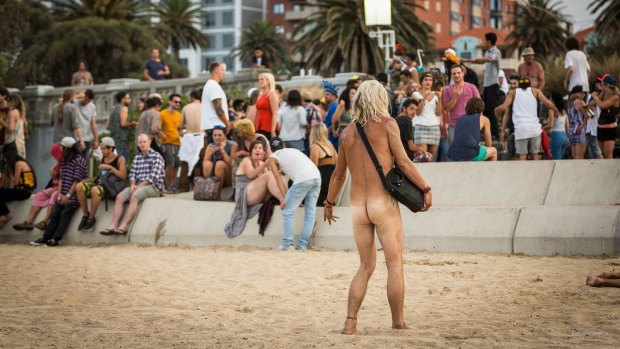 A weary partier awakes to find himself nude and highly visible at St Kilda Beach on New Year's Day.