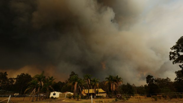 The bushfire flares over properties in Kurri Kurri