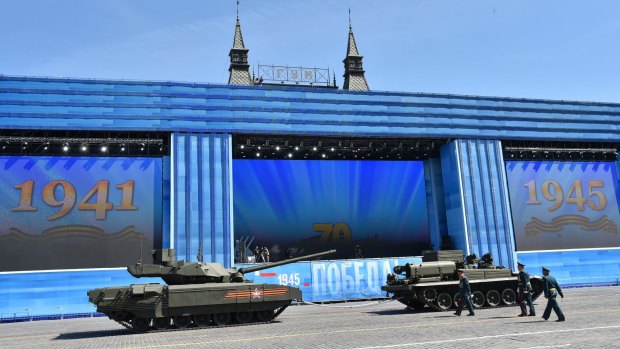 A T-14 tank (left) is ready to be towed for the Victory Day parade through Moscow's Red Square.
