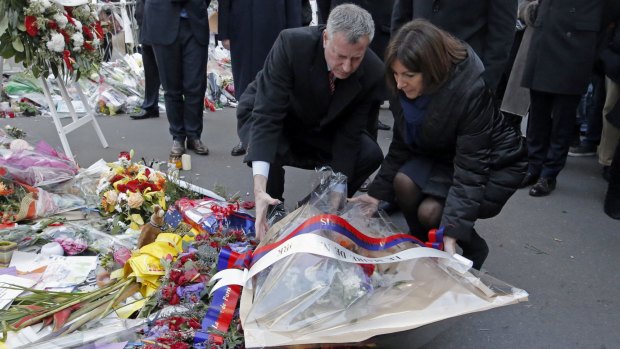 Fraternity: New York mayor Bill de Blasio, left, and Paris mayor Anne Hidalgo lay a wreath at the site of the <em>Charlie Hebdo</em> newspaper attack in Paris.
