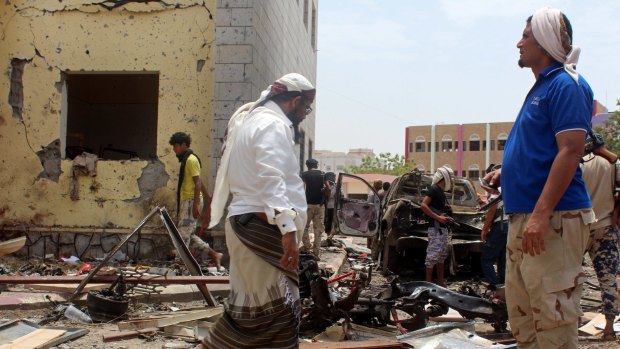 Fighters loyal to the government gather at the site of a suicide car bombing in Yemen's southern city of Aden in August.