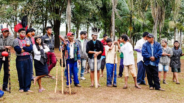 With protection totems in the ground, Kaiowa tribe members prepare for an assembly. 
