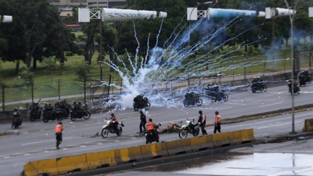 Fireworks launched by anti-government protesters explode near government forces riding past on motorbikes in Caracas.