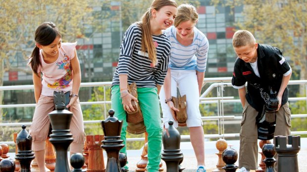 Kids playing giant chess on the top deck of a Uniworld's river-cruise ship.