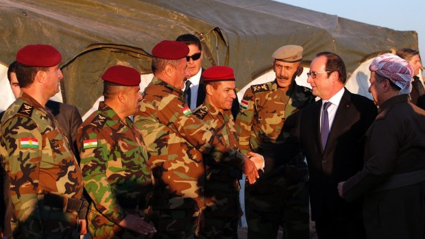President of the Iraqi self-ruled Kurdish region, Massoud Barzani, right, introduces French President Francois Hollande to Kurdish Peshmerga soldiers.