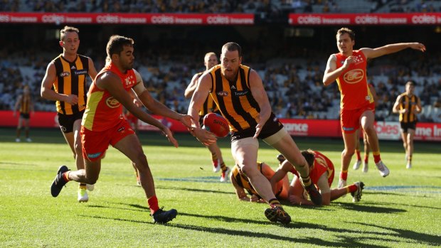 The Suns' Jack Martin and Hawks skipper  Jarryd Roughead compete for possession.