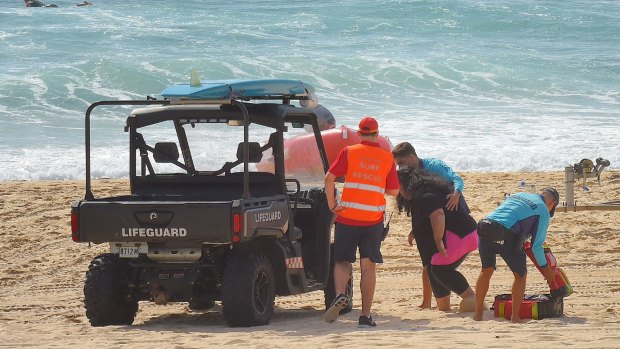 Mother Sandra Tomano is helped by lifesavers into their buggy on Tuesday.
