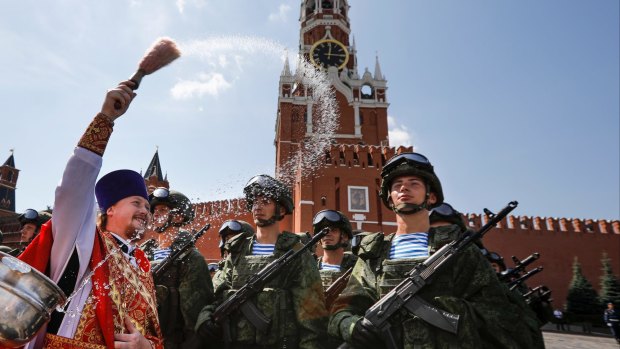 A Russian Orthodox priest blesses paratroopers during celebrations of Paratroopers Day in the Red Square in Moscow.