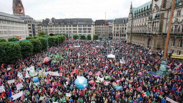 Participants of the demonstration 'G20 Protest Wave' gather in front of the city hall in Hamburg.