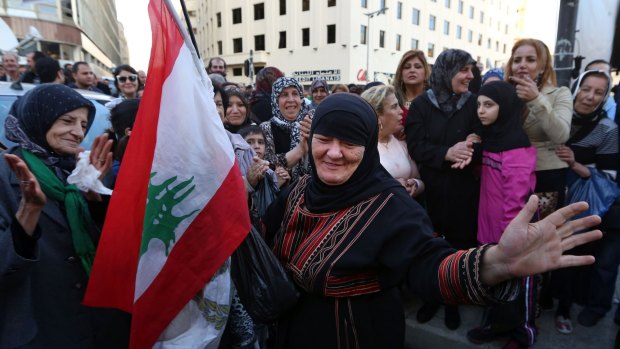 A relative of the released soldiers and policemen  dances with a Lebanese flag at the tent village set up in Beirut to protest their continued captivity.