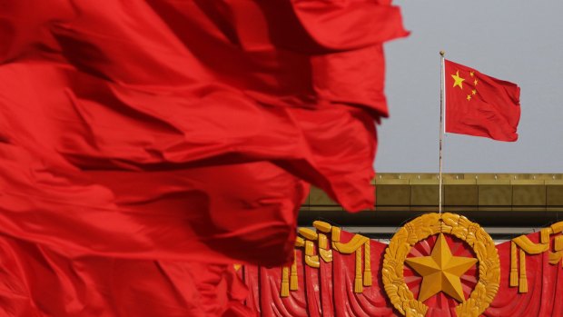Red flags fly in front of the Chinese national flag in Beijing.