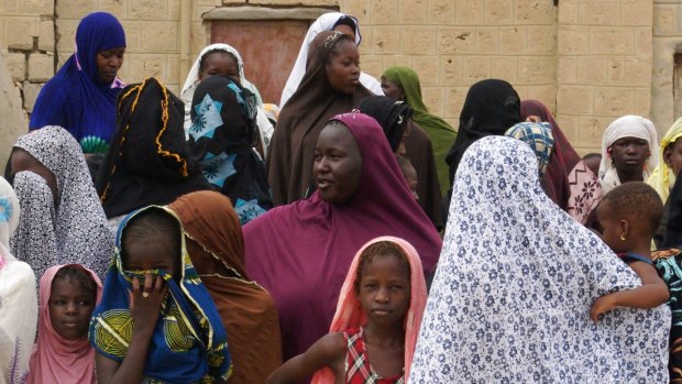 Women and girls wearing veils to comply with the dictates of Islamist group Ansar Dine wait to see the public lashing of a member of the Islamic Police found guilty of adultery in Timbuktu, Mali, in 2012.