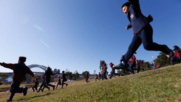 Students from Fort Street Public School race down the hill after the last tree at Sydney's newest park was planted.
