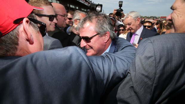Winning trainer of Prince of Penzance Darren Weir is mobbed in the mounting yard moments after winning The  Melbourne Cup  at Flemington.