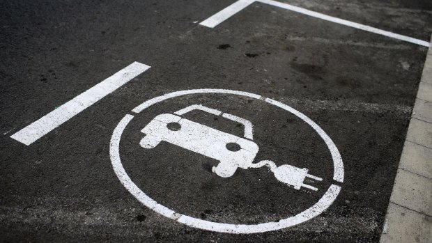 Road signs mark parking bays for drivers to use electric vehicle charging points in Spain.