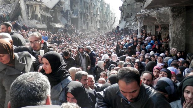 Residents of Yarmouk queuing for food in January 2014. Once home to 145,000 Palestinian refugees, the town has been taken over by Islamic State militants, forcing most residents and aid workers to leave and isolating those left behind.