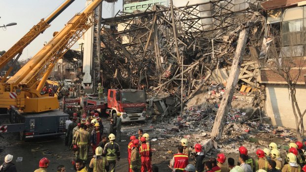 Iranian firefighters work at the scene of the collapsed Plasco building after it was engulfed by a fire.